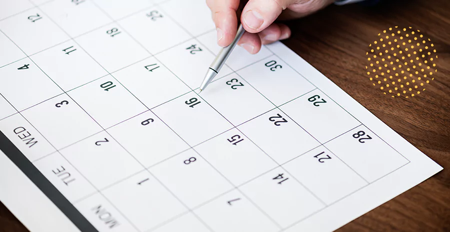 imagem de uma pessoa apontando uma caneta para um calendário
