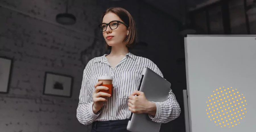 imagem de uma mulher segurando um computador e um copo