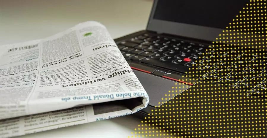 imagem de um jornal e computador sobre a mesa