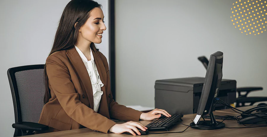 imagem de uma mulher sentada mexendo em um computador