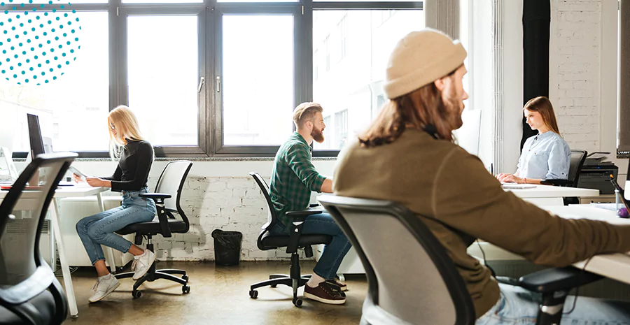 imagem de um escritório com diversas pessoas sentadas trabalhando em frente a um computador