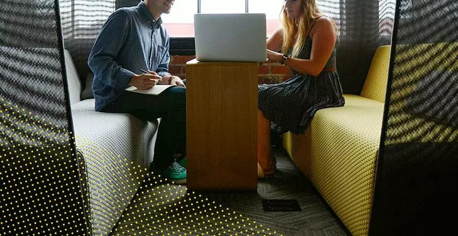 imagem de duas pessoas sentadas com uma mesa no meio