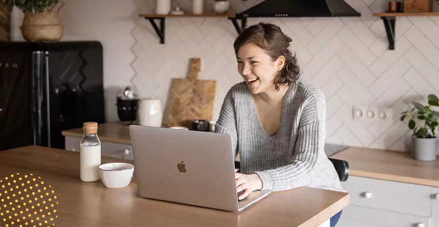 imagem de uma mulher olhando para o computador, ela ri