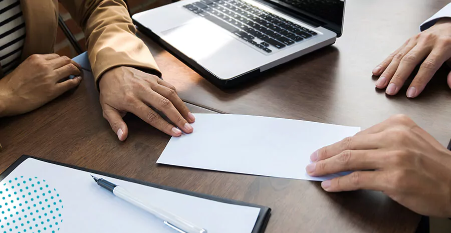 imagem de uma pessoa anotando no papel e mexendo no computador