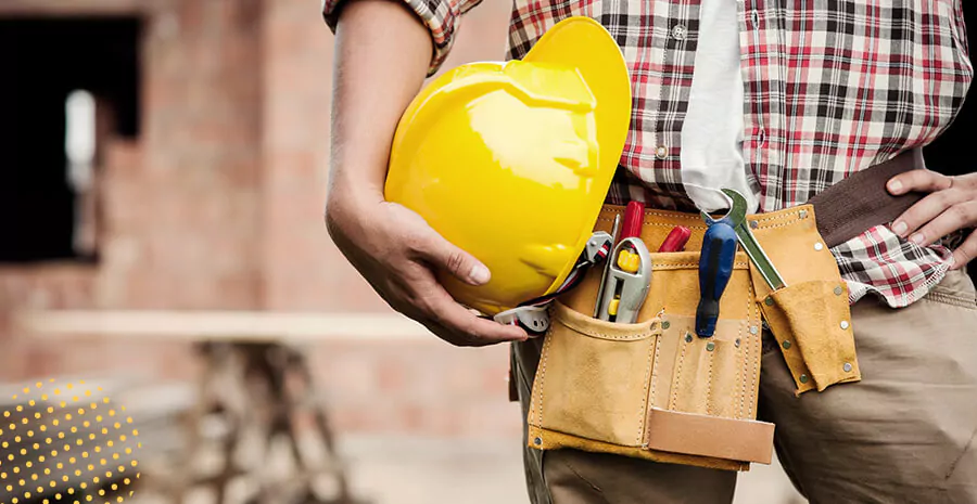 imagem de uma pessoa segurando um capacete de construção amarelo