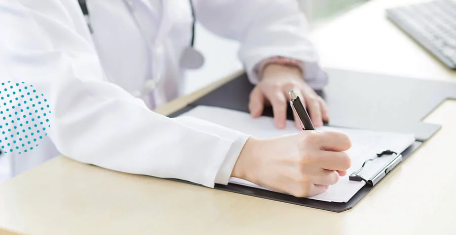 imagem de um médico escrevendo em uma folha com uma caneta preta