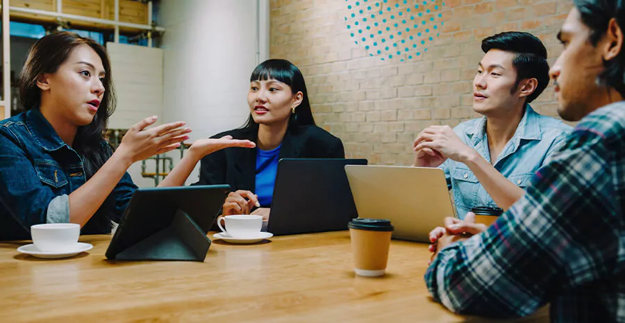 imagem de pessoas reunidas com seus computadores em cima da mesa