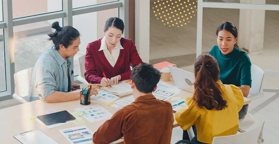 imagem de pessoas com roupas coloridas reunidas em uma mesa de reunião