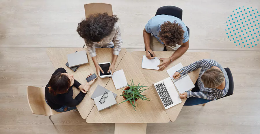 imagem com pessoas trabalhando em cima de uma mesa clara