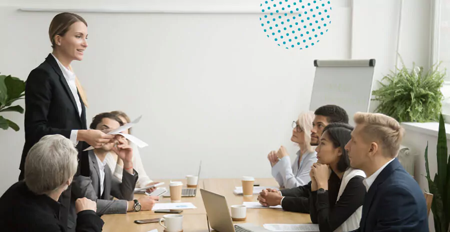 imagem de um grupo de funcionários em uma reunião sentados ao redor de uma mesa