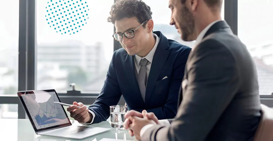 imagem de dois homens sentados na mesa olhando para um computador