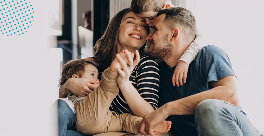 imagem de um homem e uma mulher abraçados com duas crianças