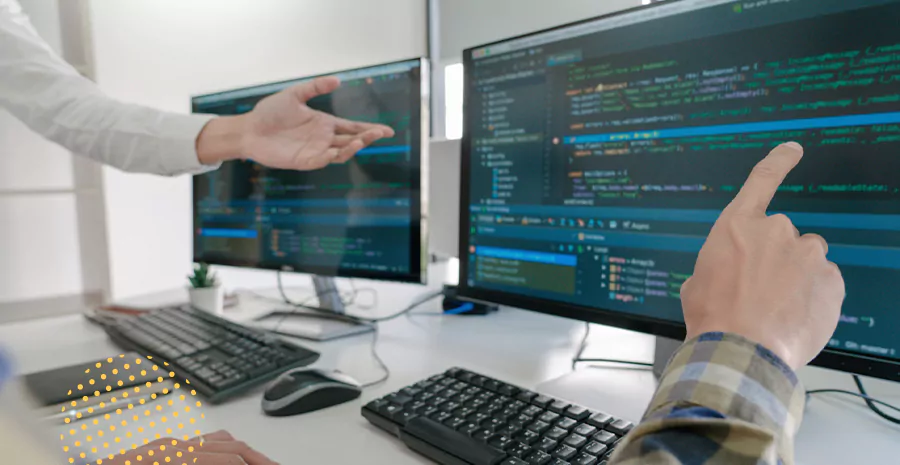 imagem de duas pessoas apontando para um computador com gráficos