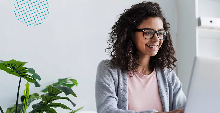 imagem de uma mulher sorrindo sentada na frente do computador