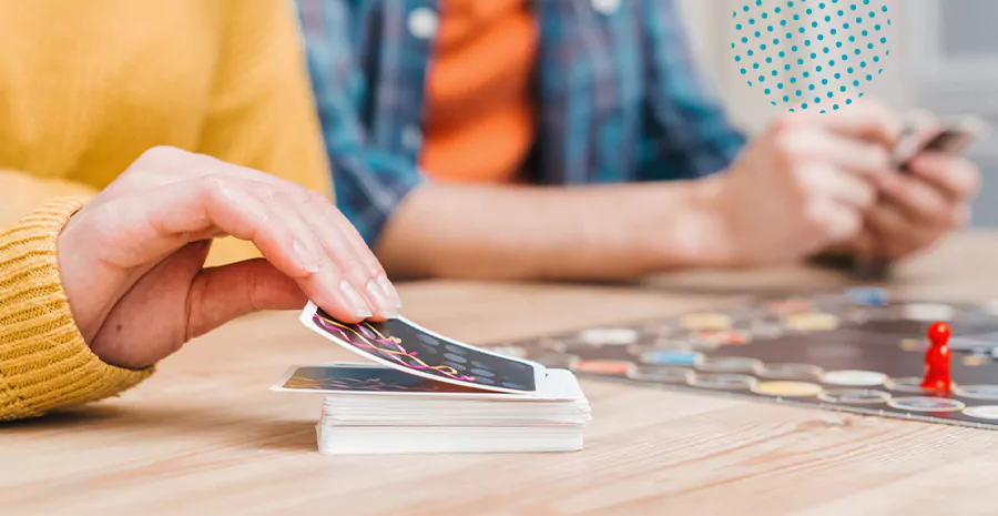 imagem de duas pessoas brincando de um jogo de cartas com um tabuleiro