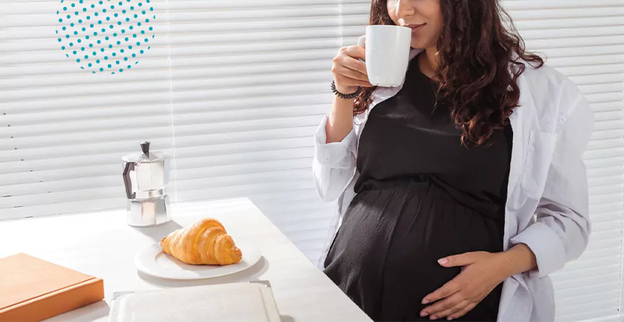 imagem de uma mulher grávida sentada tomando café