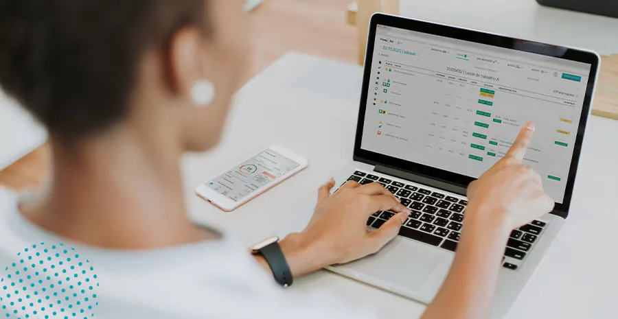 imagem de uma mulher sentada na frente de um computador usando o sistema de controle de ponto da pontotel
