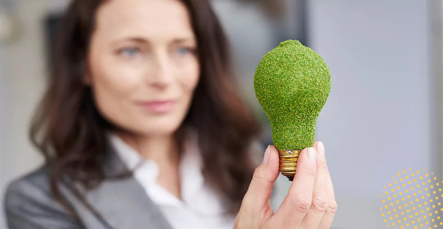 imagem de uma mulher segurando uma lâmpada verde cercada de folhas