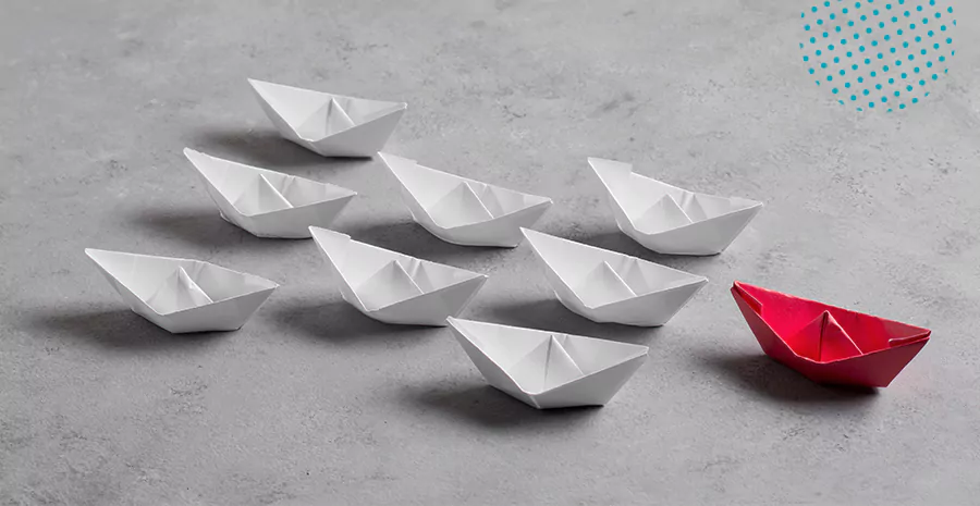 imagem de barcos de papel brancos e um barco de papel vermelho