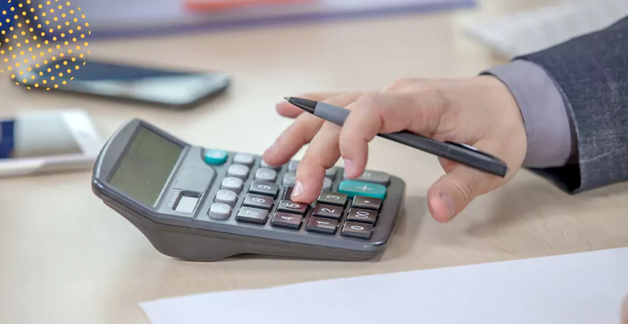 imagem de uma pessoa segurando uma caneta e usando a calculadora