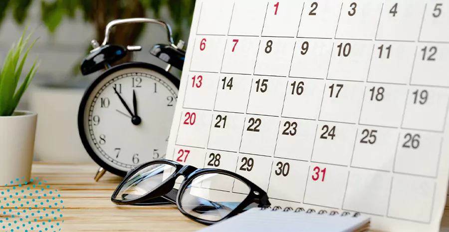 imagem de um calendário, um óculos e um relógio em cima de uma mesa