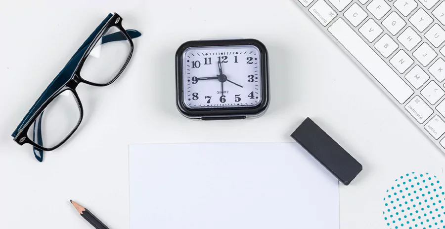 imagem de um óculos, um relógio, um teclado, um celular e um lápis em cima de uma mesa branca