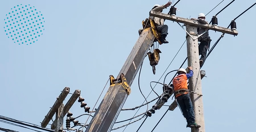 imagem de uma pessoa pendurada em um poste de energia trabalhando
