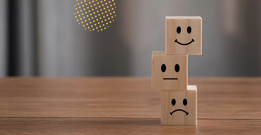 imagem de três blocos de madeira empilhados com desenhos de caras triste e sorrindo