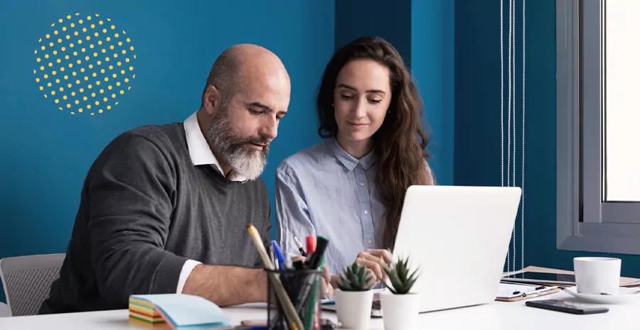 imagem de um homem e uma mulher sentados lado a lado olhando para um computador