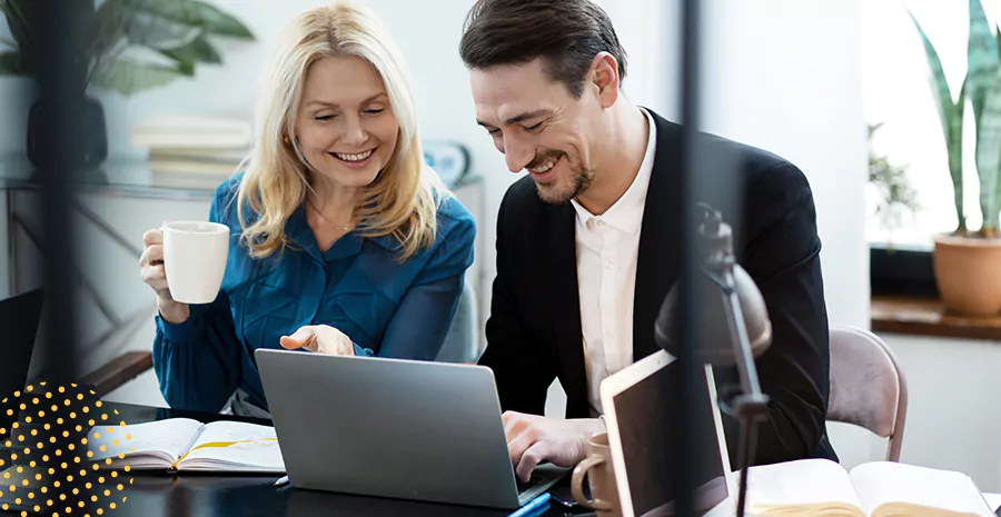 imagem de um homem e uma mulher sorrindo olhando para um computador