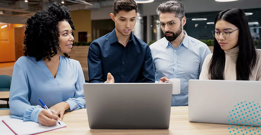 imagem de dois homens e duas mulheres conversando e olhando para computadores