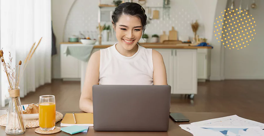imagem de uma mulher sorrindo sentada na frente de um computador