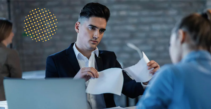 imagem de um homem sentado segurando folhas de papel