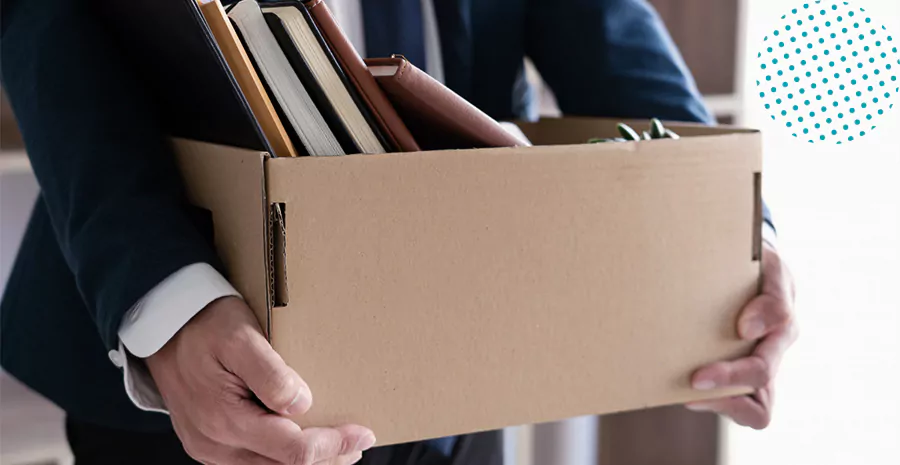 imagem de um homem segurando uma caixa de papelão com livros dentro