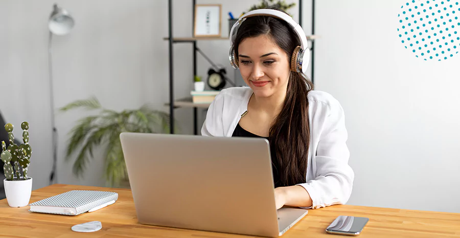 imagem de uma mulher sentada digitando em um computador e usando fone de ouvido