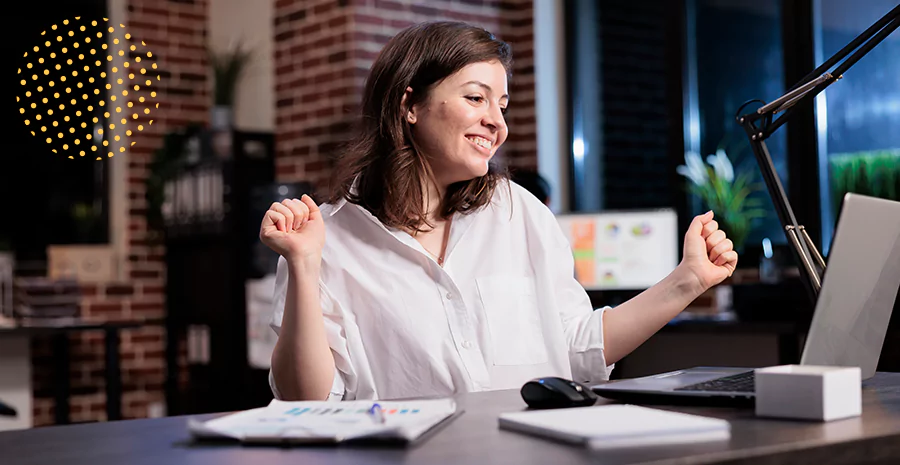 imagem de uma mulher sentada sorrindo olhando para um computador