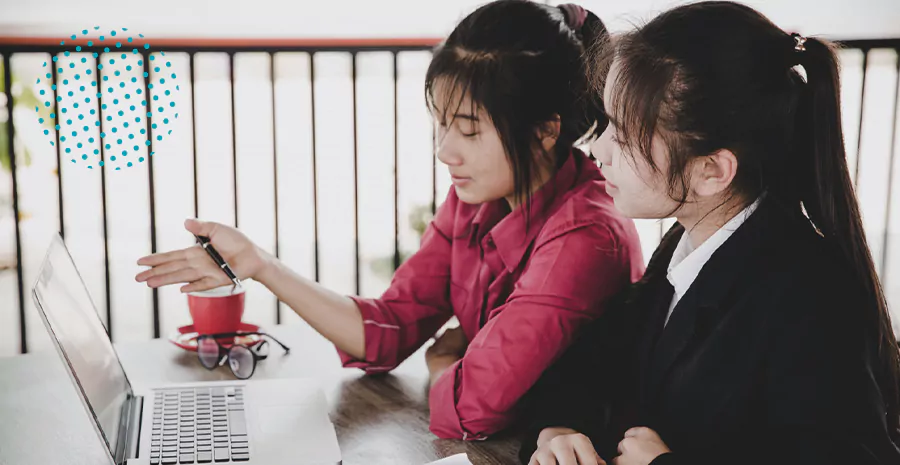 imagem de duas mulheres sentadas olhando para um computador