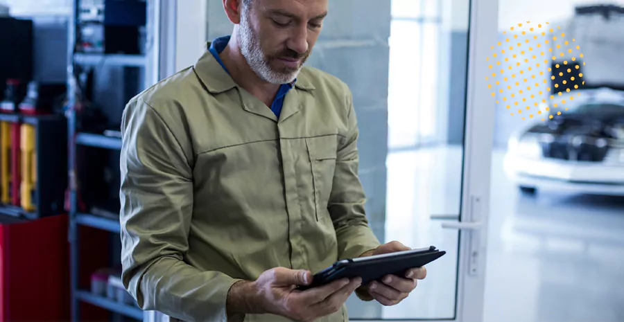 imagem de um homem em uma oficina olhando para um tablet