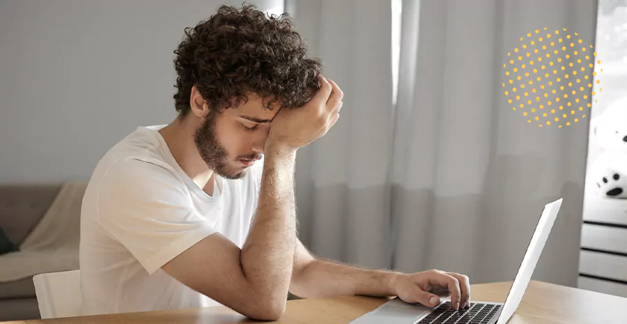imagem de um homem preocupado sentado na frente de um computador
