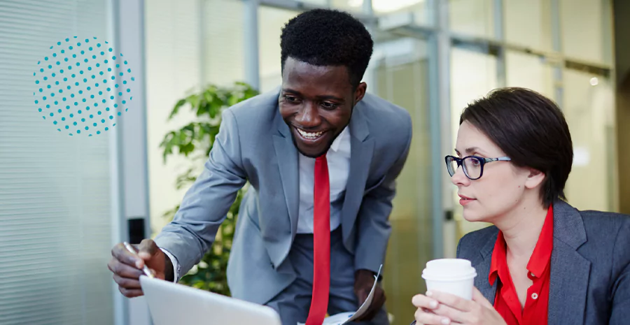 Um homem e uma mulher conversando enquanto observam a tela de um notebook