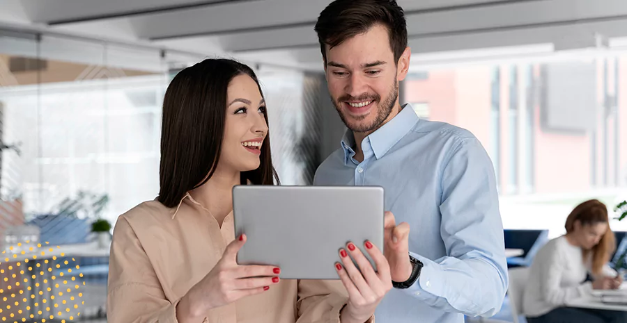 Um homem e uma mulher observando um tablet