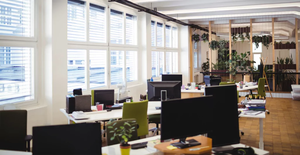 Um escritório vazio com muitas janelas e plantas