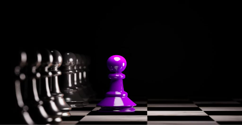 Uma peça de xadrez roxa está em frente a um grupo de peças de xadrez