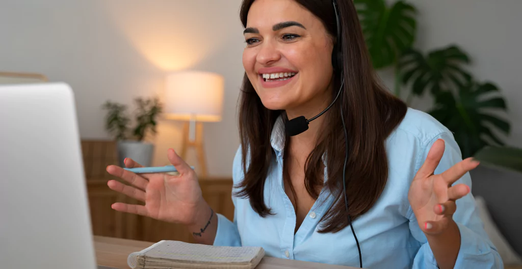 Uma mulher com fone de ouvido e laptop está conversando com alguém