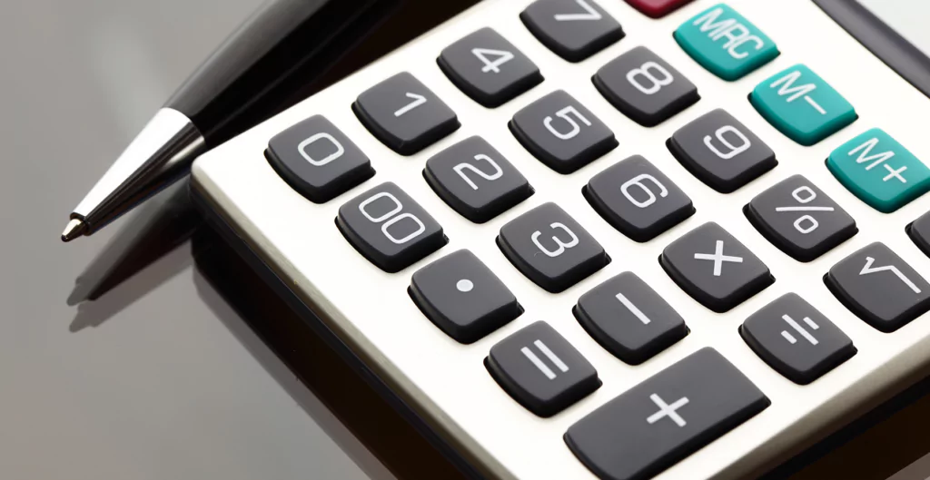 Uma calculadora e caneta em uma mesa