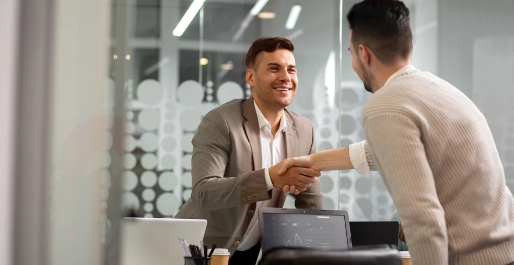 Dois homens apertando as mãos em um ambiente de escritório