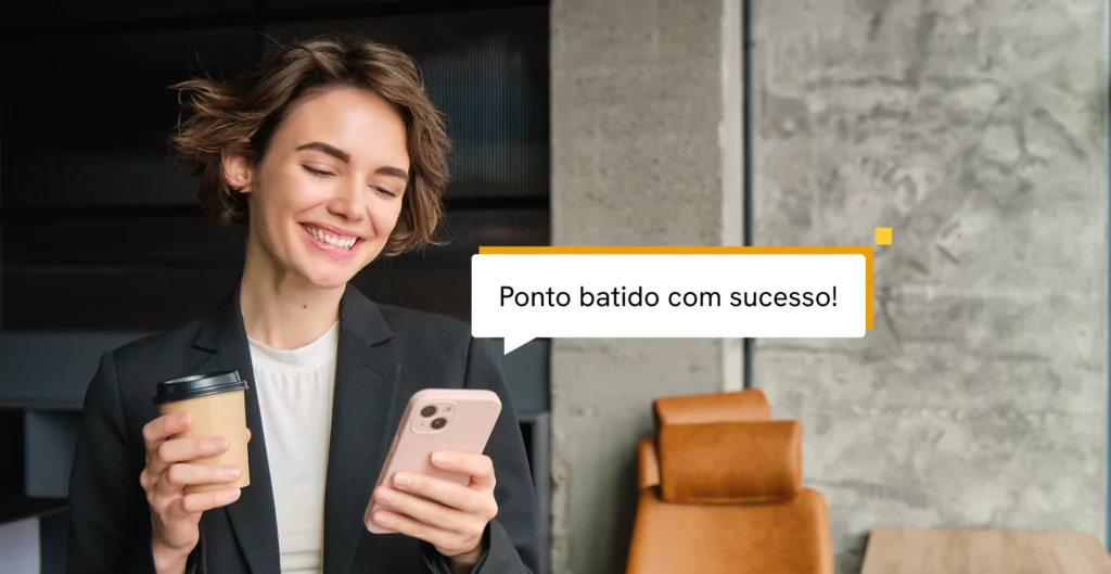 mulher sorridente segurando um copo de café e um celular 