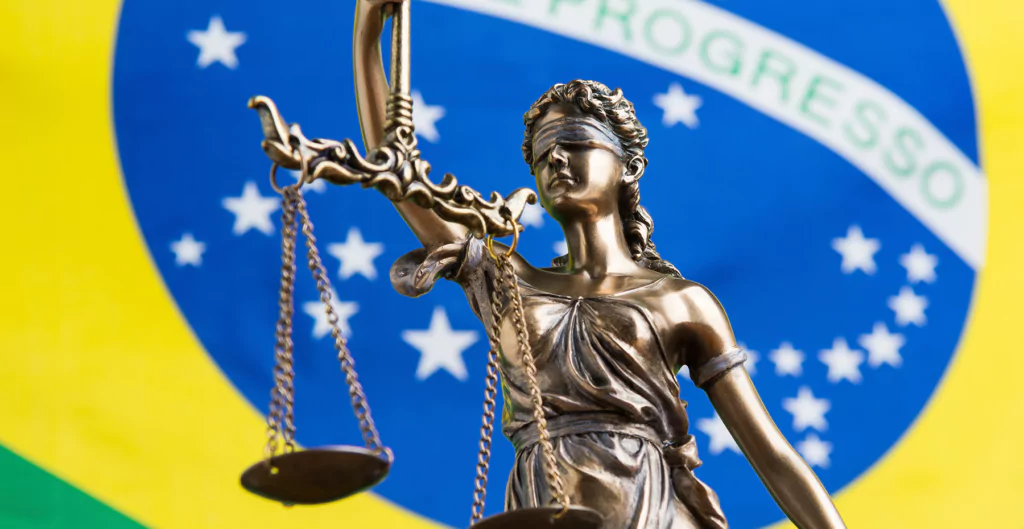 balança da justiça e bandeira do brasil ao fundo