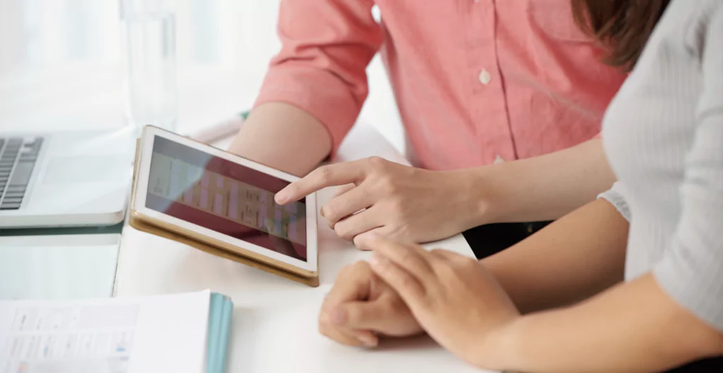 duas pessoas mexendo em um tablet 