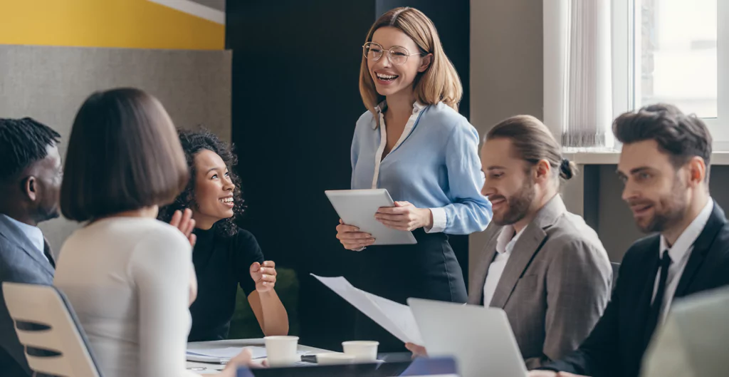 grupo de pessoas em uma sala fazendo uma reunião 